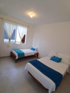 a bedroom with two beds and a window at Pajaro Brujo in Puerto Villamil