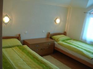 1 dormitorio con 2 camas, vestidor y ventana en Villa Vežić, en Mostar