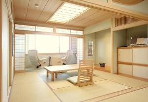 a waiting room with chairs and a table and a window at Bessou Kakei in Morioka