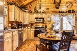 a kitchen with wooden cabinets and a table in a cabin at Along the Trail Cabin with Hot Tub Pool Pond Game Room in Wear Valley +47 photos