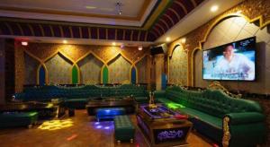 a living room with green couches and a tv at Fu'an Tailong Sea-view Hotel (Danzhou Haihua Island) in Dongshan