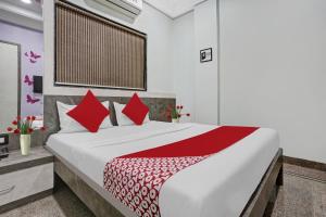 a bedroom with a large bed with red pillows at Hotel O Chhaya in Aurangabad +21 photos