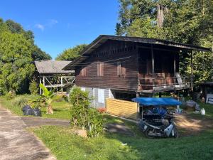 a house with a motorcycle parked in front of it at Balance home happy in Ko Yao Noi