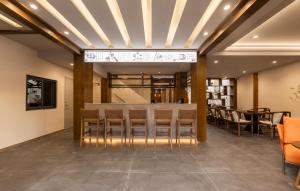 a lobby with a bar with chairs and a table at 院中院喜与漫渡酒店丽江忠义市场店 in Lijiang