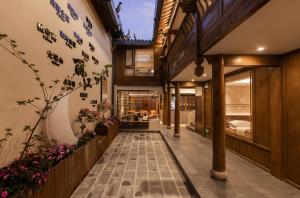 a hallway of a house with flowers on the walls at 院中院喜与漫渡酒店丽江忠义市场店 in Lijiang