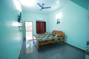 a bedroom with a bed and a ceiling fan at Somas kandar Lodge in Sūrandai