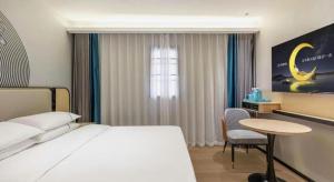 une chambre avec un lit, un bureau et une table dans l'établissement City Comfort Inn Wuhan Guanggu Textile University, à Wuhan