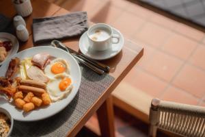 a table with a plate of breakfast food and a cup of coffee at Kira Baya Koh Samed in Ko Samed
