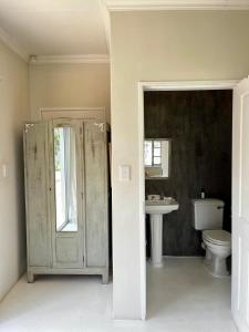 a bathroom with a toilet and a sink at Pepper Tree Guesthouse in Bloemfontein +31 photos