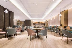 a dining room with tables and chairs and tablesktop at The Hotel V Nanjing Lishui in Lishui