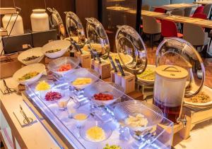 a buffet with many plates of food on a table at Borrman Hotel Dongguan Dongcheng Wanda Plaza Tianbao Metro Station in Dongguan