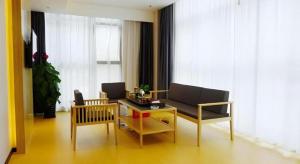 a living room with a couch and a table at GreenTree Inn Express Fuzhou Minhou County Mindu Custom Park in Minhou