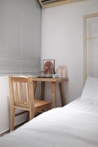 a desk in a bedroom with a bed and a chair at BenHouse Homestay in Ho Chi Minh City