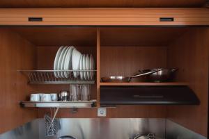 a kitchen with plates and utensils on a shelf at Nikolatos Apartments in Lóngos