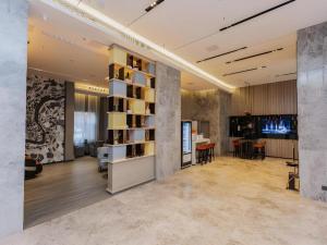 JiayuにあるEcharm Hotel Jiayulongwan Peninsulaの本棚とテーブルのあるロビー