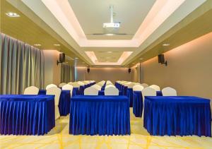 a conference room with blue tables and white chairs at Echarm Hotel Qujing High-speed Railway Station 1st Wuguan Center in Qujing