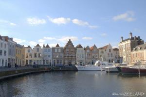 a group of boats docked in a river with buildings at Oesterbaai 36 in Wemeldinge