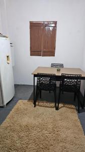 a dining room table with two chairs and a refrigerator at Aconchego da cris in Lençóis