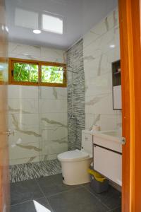 Un baño con inodoro, lavabo y ducha. en Villa my place, en Bonao