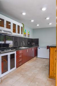 cocina grande con armarios blancos y encimera en Villa my place, en Bonao