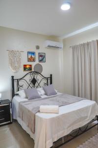 Un dormitorio con una cama grande con sábanas blancas. en Villa my place, en Bonao