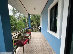 un balcone con sedie e tavoli su un edificio di Spacious House in Srithanu a Ko Kong Nui
