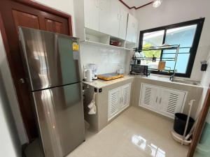 una cucina con frigorifero in acciaio inossidabile e finestra di Spacious House in Srithanu a Ko Kong Nui