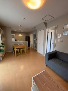 a living room with a couch and a table at 一棟貸切の民宿 月 駐車場2台無料 バス停徒歩1分 市街地へ好アクセス in Matsuyama