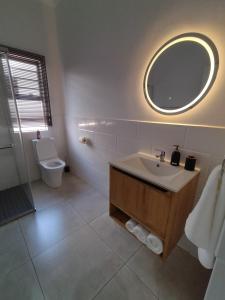 Un baño con lavabo, espejo e inodoro. en Atloch, en Kimberley