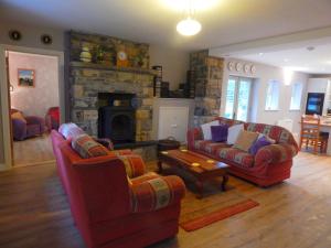 a living room with two couches and a stone fireplace at Cnoc na Ri Cottage in Ballinamore