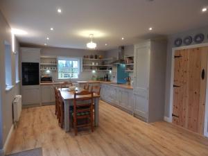 a kitchen with a wooden table and a wooden floor at Cnoc na Ri Cottage in Ballinamore