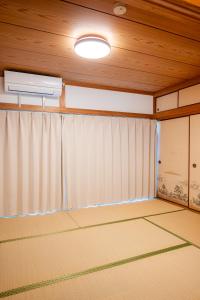 une pièce vide avec un rideau et un plafond dans l'établissement 宿 重富 Stay SHIGETOMI, à Aira