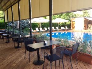 a restaurant with tables and chairs next to a pool at Hotel Perperikon in Kŭrdzhali