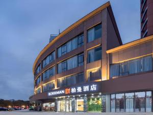 Un gran edificio con un cartel delante. en Borrman Hotel Suzhou Wujiang Zhongshan North Road Pedestrian Street, en Suzhou