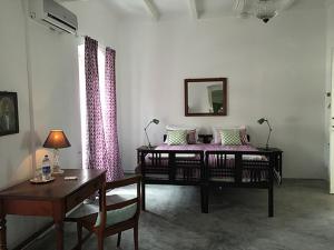 a room with two beds and a table and a desk at Villa Helena in Pondicherry +35 photos