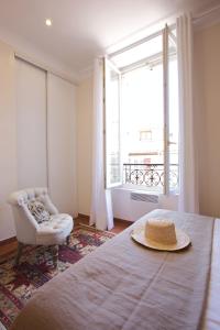 um quarto com uma cama, uma cadeira e uma janela em 15 Cours Massena em Antibes