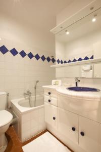 La salle de bains blanche est pourvue d'un lavabo et de toilettes. dans l'établissement 15 Cours Massena, à Antibes