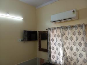 a room with a heater and a curtain and a mirror at A V Palace Guest House Raika bagh Jodhpur in Jodhpur