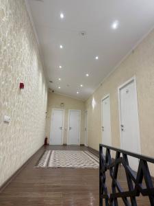 a hallway with three white doors and a staircase at Manija Hostel in Samarkand