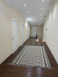 an empty hallway with doors and a rug on the floor at Manija Hostel in Samarkand +5 photos