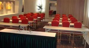 una sala de conferencias con sillas rojas, mesas y escritorios en Jinjiang Inn Shenyang Northeastern University, en Shenyang