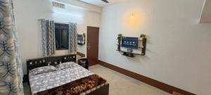 a bedroom with a bed and a tv on a wall at Hotel Purvanchal in Katihār