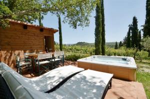 eine Whirlpool-Badewanne im Hof mit Tisch in der Unterkunft Sestuccina in Gaiole in Chianti