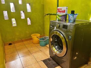 a washing machine in a bathroom with a green wall at Majestic Two-bedroom House in a prime location in Nairobi