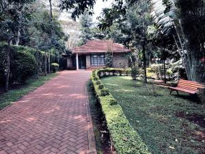 a brick path in front of a building with a bench at Majestic Two-bedroom House in a prime location in Nairobi