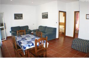 a living room with a table and a couch at Apartamentos La Palmera in Conil de la Frontera