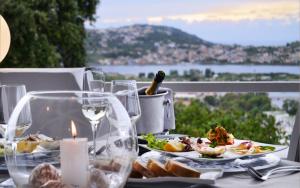 a table with a plate of food and wine glasses at Hotel Cala Moresca in Bacoli