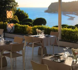 a restaurant with tables and chairs with a view of the ocean at Hotel Cala Moresca in Bacoli