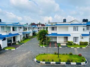 a row of houses with blue roofs in a parking lot at Zenaura Casa Villa 2 in Cochin