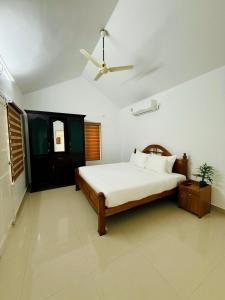 Un dormitorio con una cama y un ventilador de techo. en Zenaura Casa Villa 2, en Kochi 26 fotos más